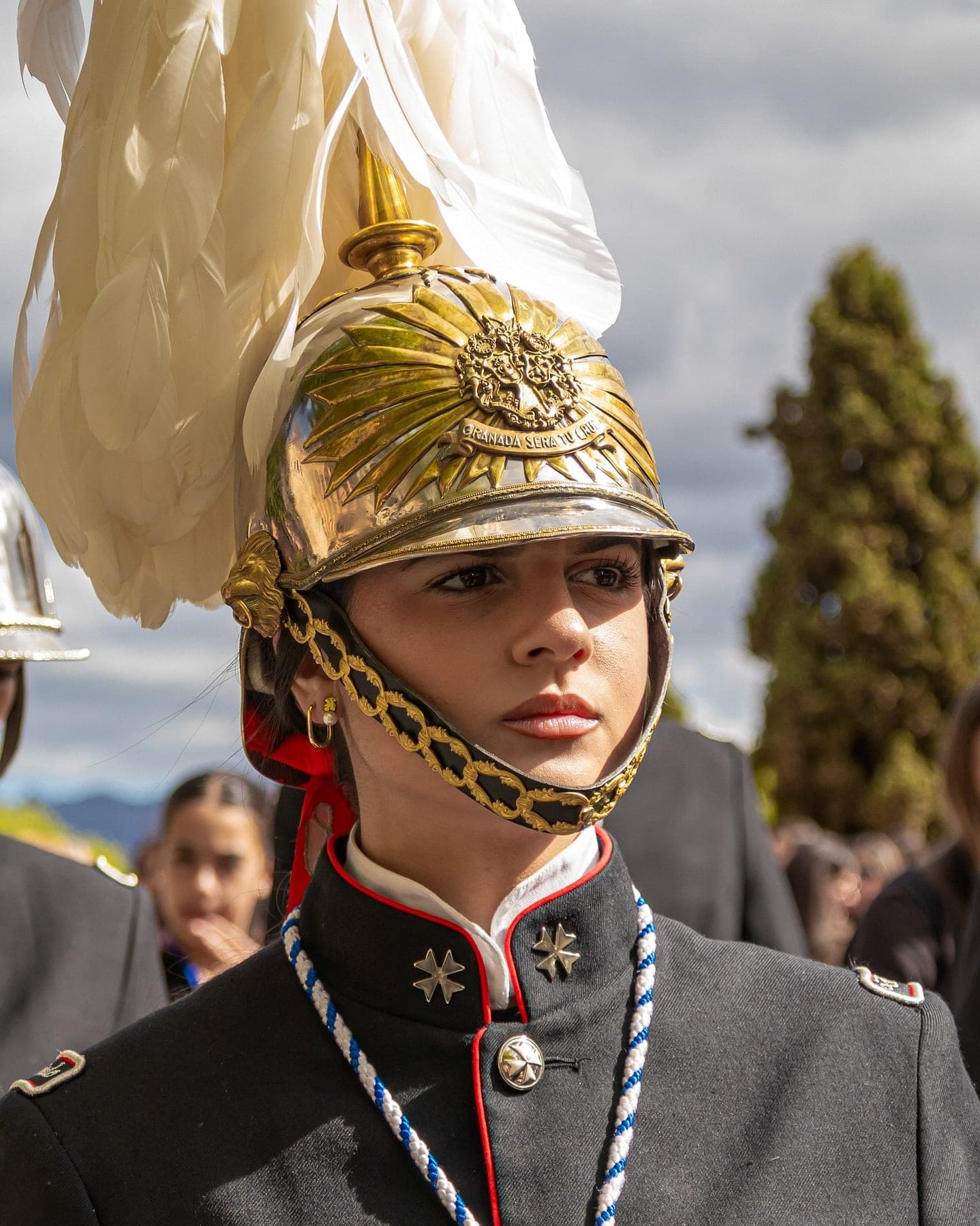 Retrato de un músico de la banda con el casco dorado y el penacho